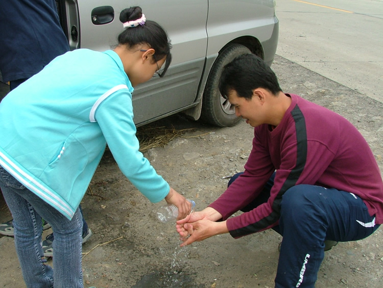 一学生为宋师兄倒水洗手