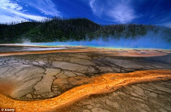 这是黄石国家公园中途喷泉盆地在火山喷发后破败景象的艺术想象图