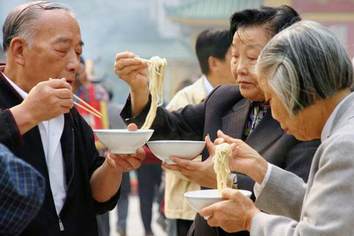 10月19日，几位老人在毗卢寺品尝长寿面。